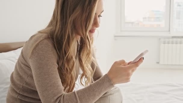 Uma Jovem Mulher Loira Bonita Está Usando Seu Smartphone Enquanto — Vídeo de Stock