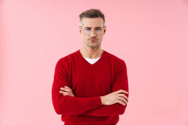 Gözlüklü yakışıklı beyaz adamın portresi pembe arka planda tek başına duruyor.