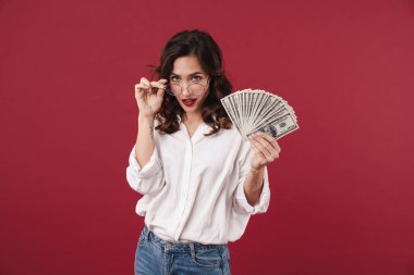 Kırmızı duvar arkasında izole edilmiş genç ve güzel bir kadının resmi..