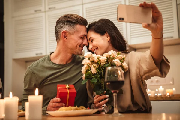 Obraz Szczęśliwy Kaukaski Para Biorąc Selfie Zdjęcie Kwiatami Podczas Romantycznej — Zdjęcie stockowe