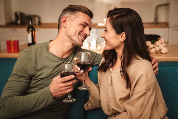 图为一对充满热情的情侣在家中享用浪漫烛光晚餐时用眼镜喝红酒的情景 — 图库照片