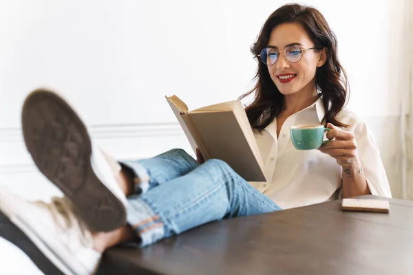 Giovane Donna Bruna Allegra Che Legge Libro Mentre Rilassa Casa — Foto Stock