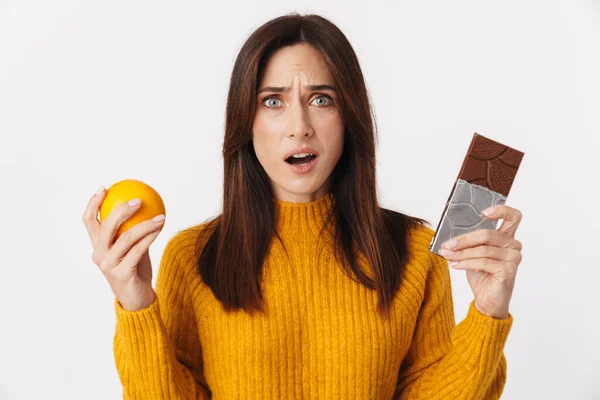 Image Doubtful Brunette Adult Woman Hesitating While Holding Orange Chocolate — Stock Photo, Image