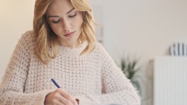 Une Jeune Femme Blonde Concentrée Écrit Exercice Dans Endroit Confortable — Video