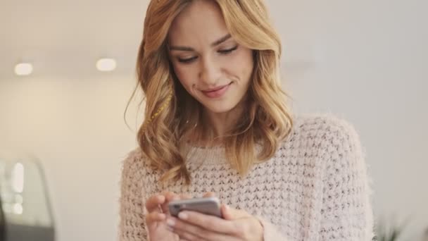 Una Mujer Sonriente Tranquila Está Usando Teléfono Inteligente Mientras Está — Vídeo de stock