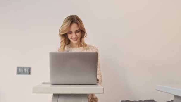 Una Joven Optimista Sonriente Está Usando Computadora Portátil Mientras Está — Vídeos de Stock