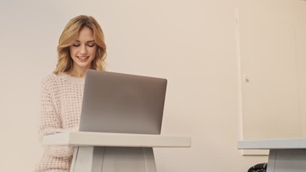 Μια Όμορφη Χαμογελαστή Ξανθιά Γυναίκα Εργάζεται Ασημί Φορητό Υπολογιστή Της — Αρχείο Βίντεο