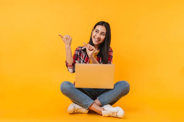 Sarı Arka Planda Dizüstü Bilgisayarı Olan Neşeli Hoş Bir Kadının — Stok fotoğraf