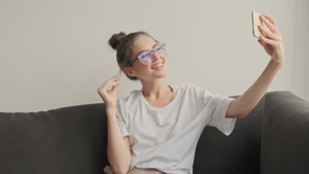 Mujer Morena Sonriente Con Gafas Vista Usando Smartphone Como Espejo — Vídeos de Stock