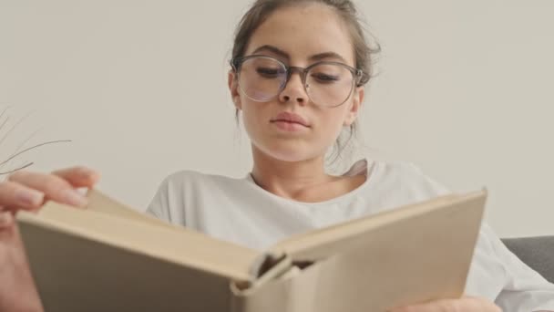 View Serious Pretty Brunette Woman Eyeglasses Διαβάζοντας Βιβλίο Ενώ Κάθεται — Αρχείο Βίντεο