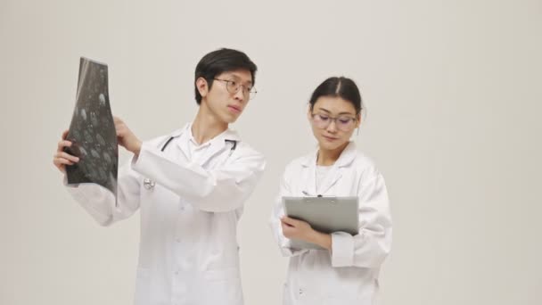 Fiatal Ázsiai Koncentrált Orvosok Izolált Fehér Háttér Steril Egyenruha Gazdaság — Stock videók