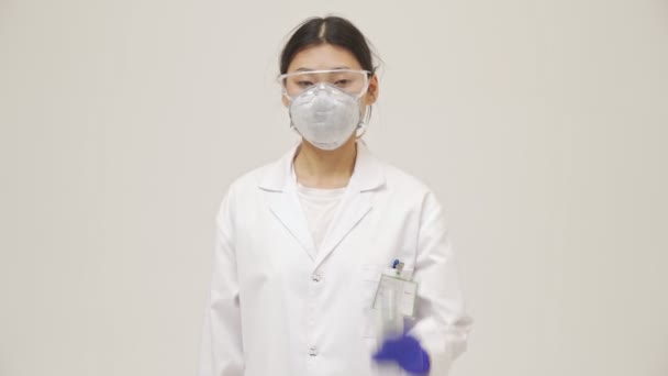 用无接触式温度计测量无菌均匀温度的年轻亚洲阴性女医生在白墙背景下被隔离 — 图库视频影像