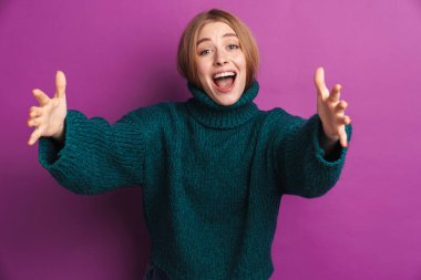 Mor duvar arkasında yalnız poz veren neşeli, iyimser genç bir kadın görüntüsü size sarılıyor..