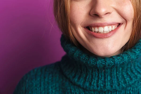 緑のセーターで明るい白人女性の撮影笑顔でカメラで隔離された上に紫色の壁 — ストック写真