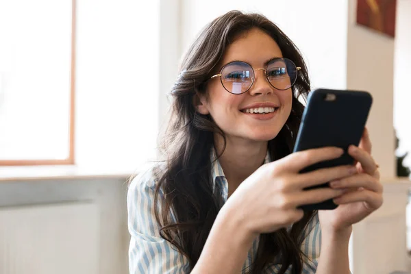 Adorável Sorrindo Jovem Morena Sentada Mesa Café Dentro Casa Usando — Fotografia de Stock