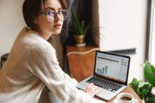 Imagem Jovem Mulher Branca Bonita Usando Óculos Usando Laptop Enquanto — Fotografia de Stock