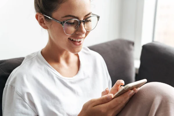 Imagen Una Mujer Joven Con Anteojos Sonriendo Escribiendo Teléfono Celular — Foto de Stock