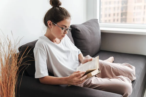 Image Serious Caucasian Woman Eyeglasses Reading Book While Sitting Sofa — Stock Photo, Image