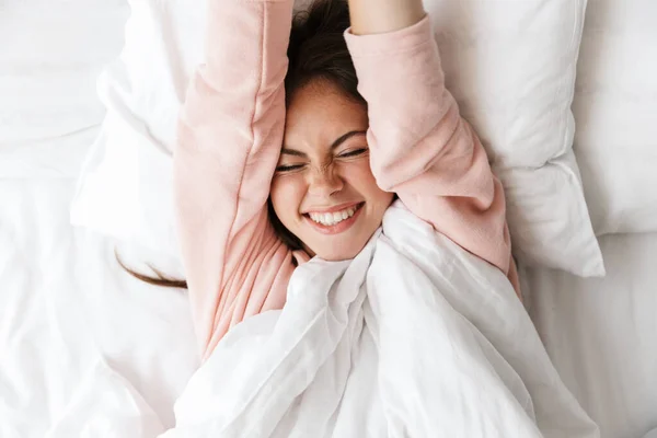 Χαρούμενη Όμορφη Νεαρή Κοπέλα Που Φοράει Πιτζάμες Ξεκουράζεται Στο Κρεβάτι — Φωτογραφία Αρχείου
