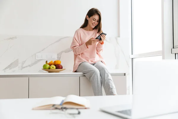 Fröhliche Schöne Mädchen Sitzt Auf Einem Küchentisch Mit Schale Mit — Stockfoto