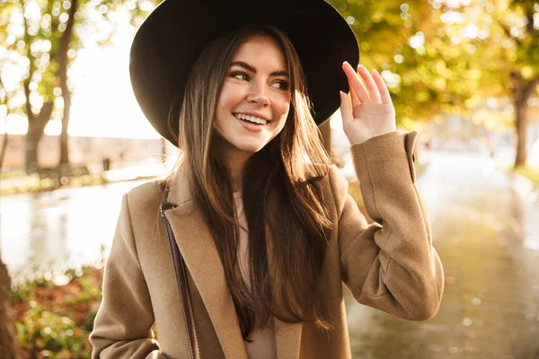 Portret Pozytywnej Młodej Brunetki Płaszczu Kapeluszu Spacerującej Jesiennym Parku — Zdjęcie stockowe