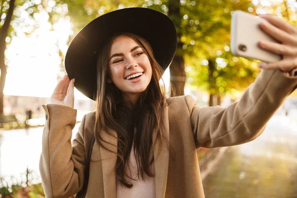 Portret Eleganckiej Kobiety Płaszczu Kapeluszu Robiącej Selfie Komórce Podczas Spaceru — Zdjęcie stockowe