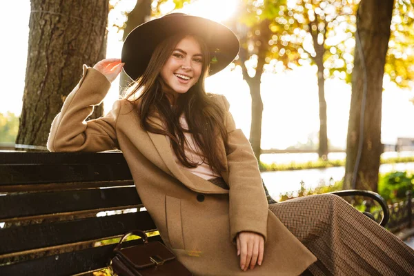 Портрет Вкусом Молодой Брюнетки Пальто Шляпе Сидящей Скамейке Осеннем Парке — стоковое фото