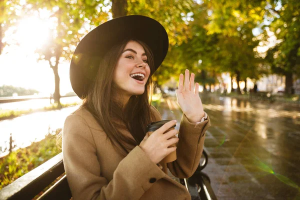 Портрет Веселой Женщины Пальто Шляпе Сидящей Скамейке Чашкой Кофе Осеннем — стоковое фото