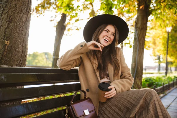 Портрет Элегантной Женщины Пальто Шляпе Сидящей Скамейке Чашкой Кофе Осеннем — стоковое фото