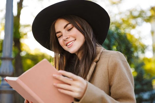 Portrait Jeune Femme Joyeuse Vêtue Manteau Chapeau Lisant Extérieur — Photo