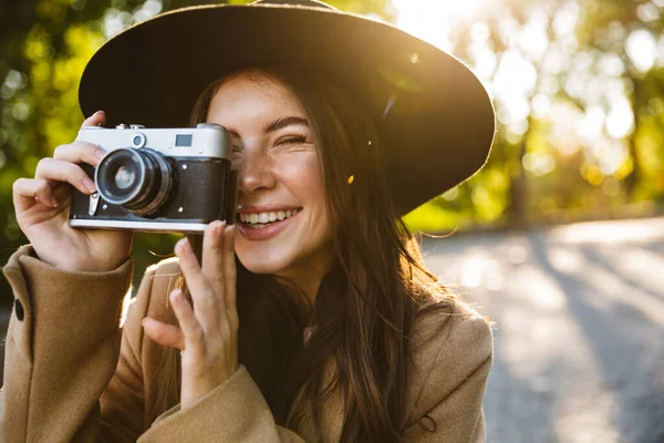 Imagen Mujer Adorable Sombrero Sonriendo Mientras Toma Fotos Cámara Retro —  Fotos de Stock