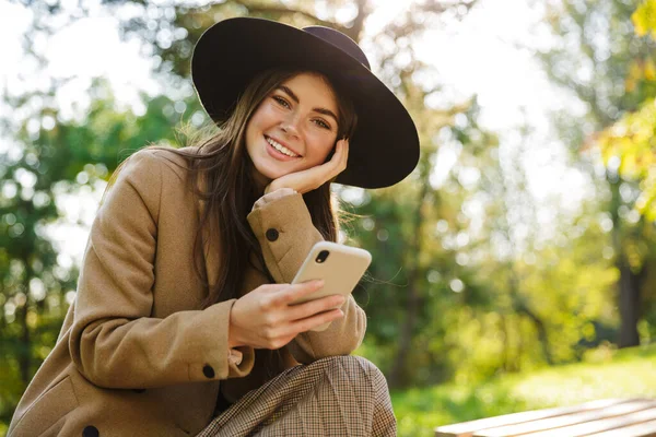 Imagen Una Mujer Alegre Con Abrigo Sombrero Otoño Usando Teléfono —  Fotos de Stock