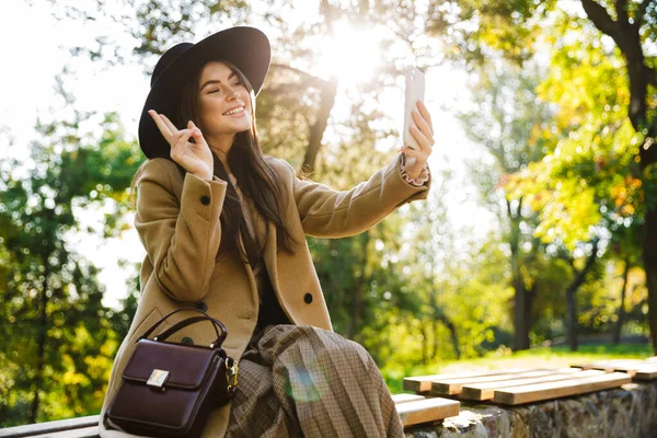 Imagen Una Mujer Sonriente Con Abrigo Sombrero Otoño Usando Teléfono —  Fotos de Stock
