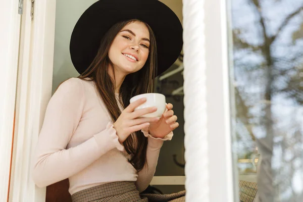 Imagen Una Mujer Joven Con Sombrero Sonriendo Mientras Toma Una —  Fotos de Stock