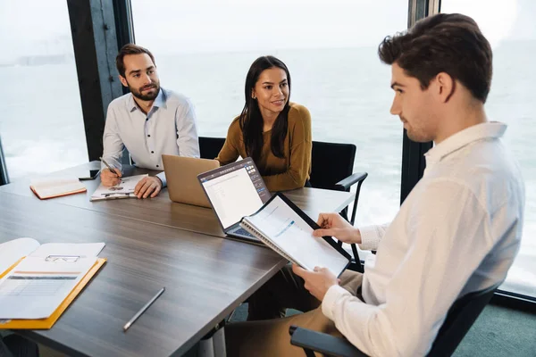 Bild Von Multiethnischen Jungen Kolleginnen Und Kollegen Die Tisch Sitzen — Stockfoto