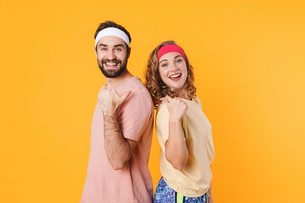 Retrato Pareja Joven Atlética Con Diademas Sonriendo Señalándose Con Los — Foto de Stock