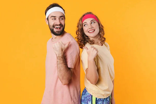 Retrato Pareja Joven Atlética Con Diademas Sonriendo Señalándose Con Los — Foto de Stock