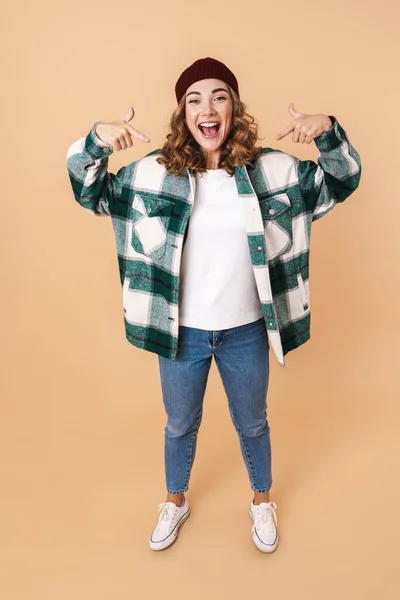 Foto Von Hübschen Fröhlichen Frau Strickmütze Zeigt Mit Den Fingern — Stockfoto