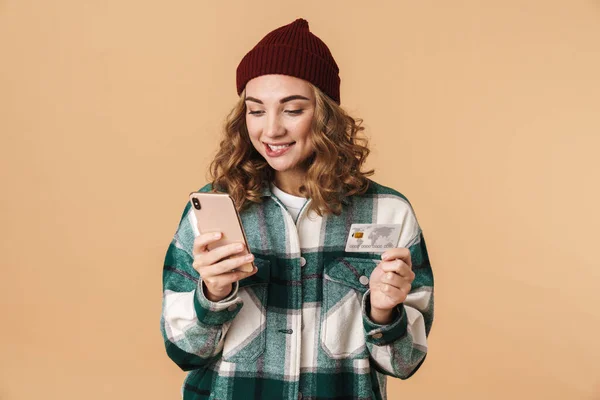 Foto Mulher Alegre Agradável Chapéu Malha Segurando Cartão Crédito Celular — Fotografia de Stock