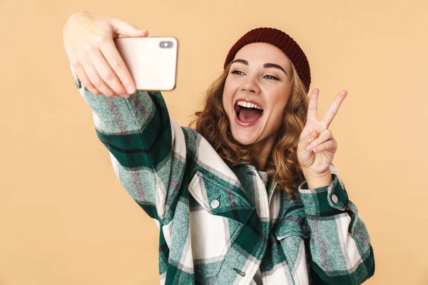 Fotografie Veselé Ženy Pleteném Klobouku Selfie Mobilu Gestikulující Mírové Znamení — Stock fotografie