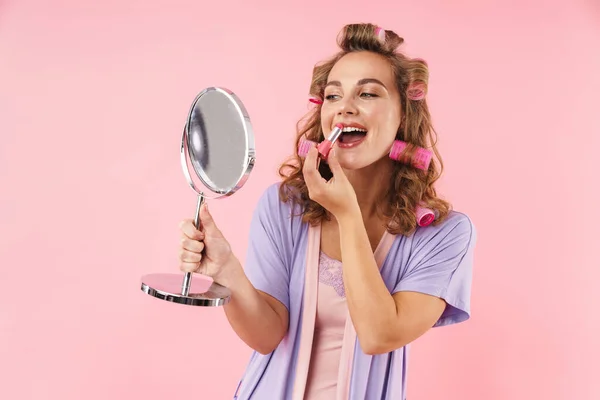 Image Pleased Young Woman Curlers Applying Lipstick Looking Mirror Isolated — Stock Photo, Image