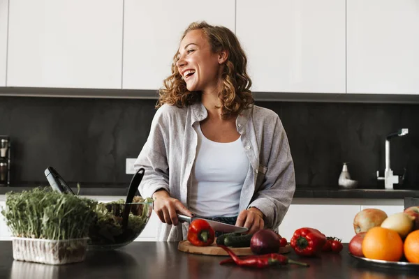 Jovem Feliz Fazendo Uma Salada Cozinha Cortando Legumes — Fotografia de Stock