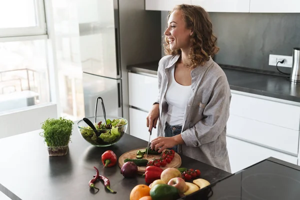 Jovem Feliz Fazendo Uma Salada Cozinha Cortando Legumes — Fotografia de Stock