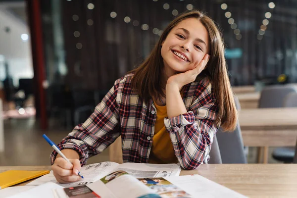 Bild Eines Fröhlichen Kaukasischen Mädchens Das Hausaufgaben Mit Schulbüchern Macht — Stockfoto