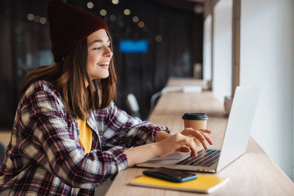 Image Joyful Caucasian Girl Hat Drinking Coffee Using Laptop While — Stock Photo, Image