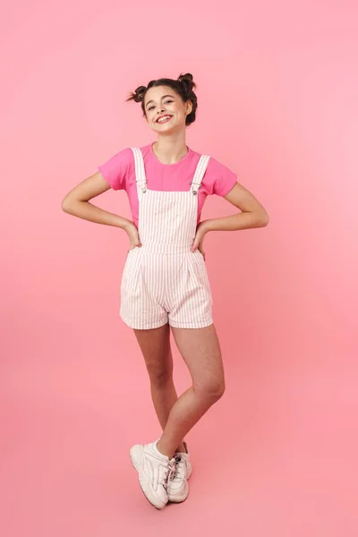 照片中可爱迷人的女孩穿着工作服 对着被粉色背景隔开的相机摆姿势微笑 — 图库照片