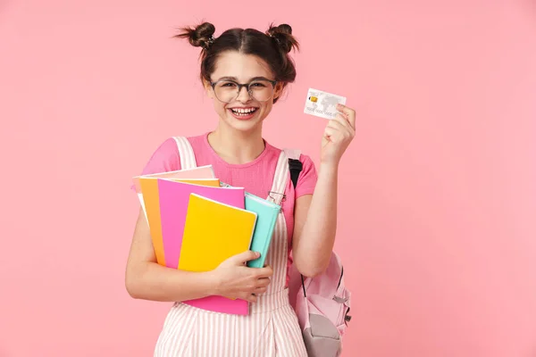 写真の笑い素敵な女の子で眼鏡保持運動本とクレジットカード隔離上のピンクの背景 — ストック写真