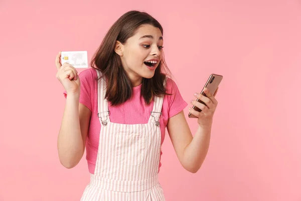 Foto Encantadora Menina Encantadora Expressando Surpresa Enquanto Segurando Celular Cartão — Fotografia de Stock