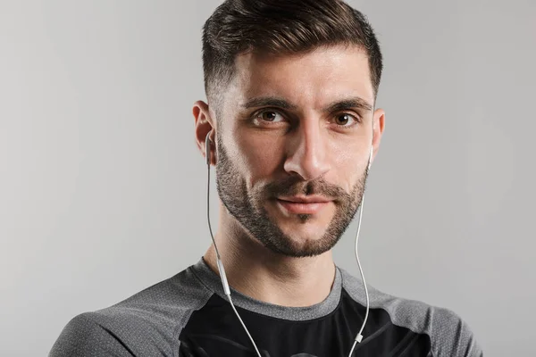 Εικόνα Του Νεαρού Αξύριστου Αθλητή Που Χρησιμοποιεί Ακουστικά Και Κοιτάζει — Φωτογραφία Αρχείου