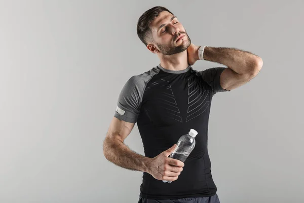 Imagem Jovem Cansado Sportswear Segurando Garrafa Água Tocar Seu Pescoço — Fotografia de Stock